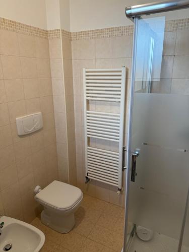 a bathroom with a white toilet and a sink at Illumina House 2 in Giurdignano