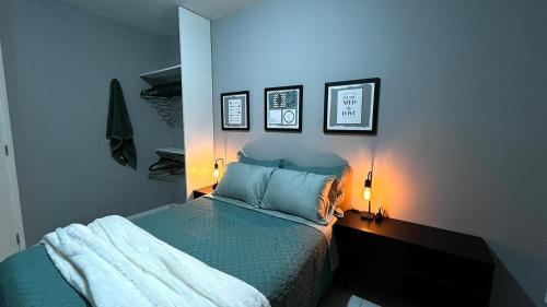 a bedroom with a bed and two lights on the wall at Apartamento Moderno em Floripa - Ideal para Famílias in São José