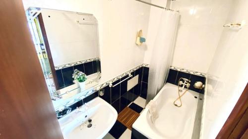 a bathroom with a sink and a mirror and a tub at O Cantinho do Pargo in Ponta do Pargo