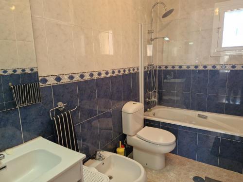 a bathroom with a toilet and a tub and a sink at Villa Oliver in Mazarrón