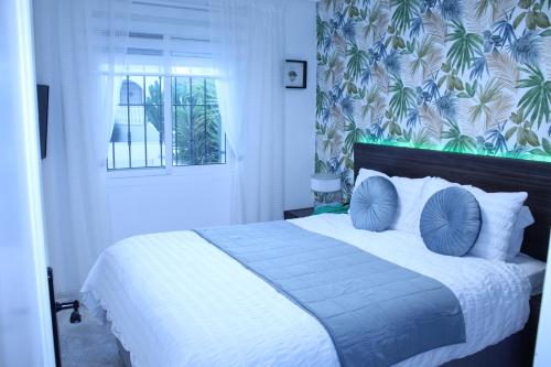a bedroom with a large bed with blue pillows at Villa Oliver in Mazarrón
