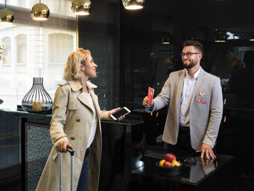 a man and a woman standing next to a table at Aparthotel Adagio Genève Mont-Blanc in Geneva