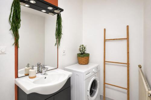 a bathroom with a sink and a washing machine at Chamotte Hyper Centre WIFI Cosy in Bourg-en-Bresse