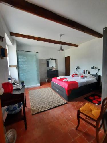 a bedroom with a bed and a tv in it at l'Estagnol in Ansouis