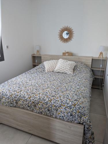 a bed in a bedroom with a mirror on the wall at Doume et Coco T1 30M2 Vue mer in Taglio-Isolaccio