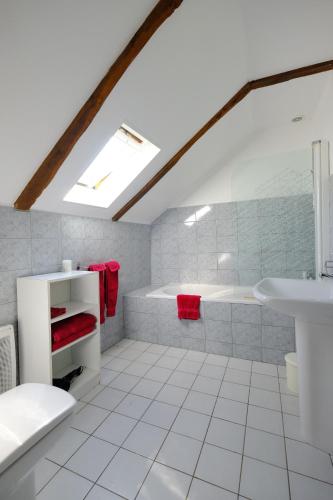 a white bathroom with a tub and a sink at Ferme de Lamourio in Saint-Cernin