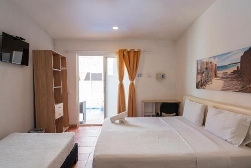 a hotel room with two beds and a window at Casa Crespo in Cartagena de Indias