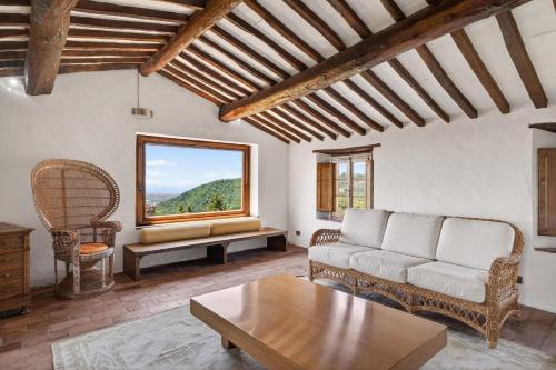 a living room with a couch and a table and a window at La Migliana by Nicola Real Estate in Corsanico-Bargecchia