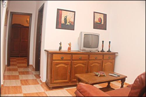 una sala de estar con TV en una cómoda de madera en Apartamento San José Conil, en Conil de la Frontera