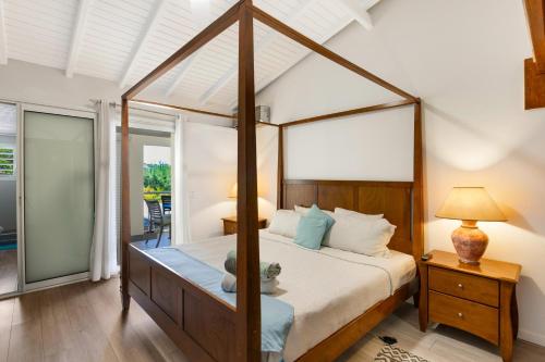 a bedroom with a canopy bed in a room at La Source Guest House in Orient Bay