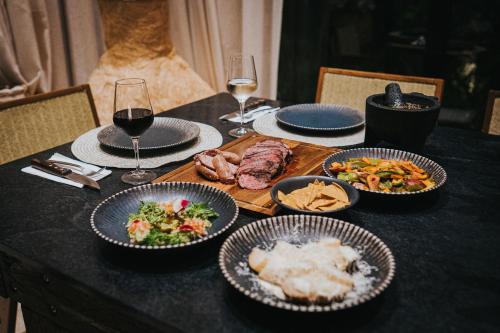 a table with plates of food and glasses of wine at Trobbu Boutique Collection Riviera Maya - All inclusive in Tulum