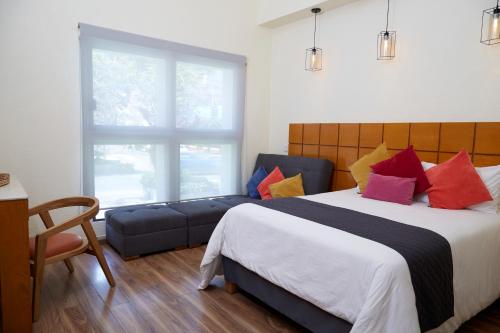 a bedroom with a large bed and a couch at Hotel Consulado in Guadalajara