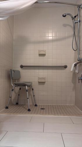 ein Badezimmer mit Stuhl und Dusche in der Unterkunft Heritage Hotel, Golf & Conference Center in Southbury