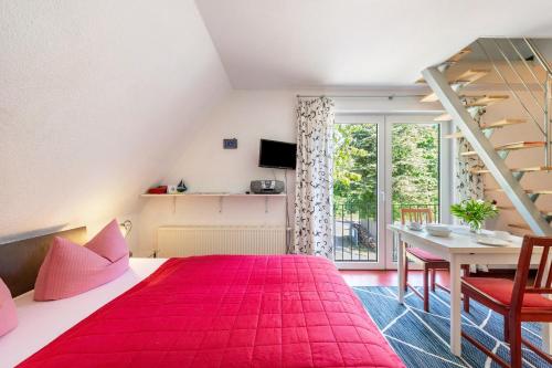 a bedroom with a red bed and a table at Ostsee in Diedrichshagen