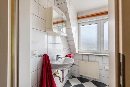 a white bathroom with a sink and a window at Ostsee in Diedrichshagen