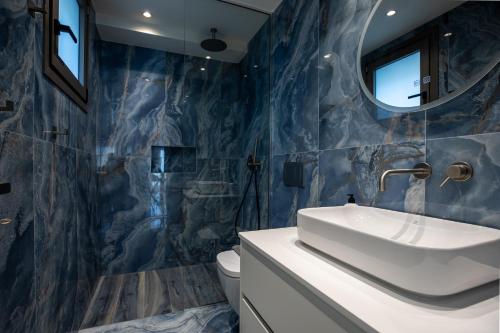 a bathroom with a sink and a mirror at Santerra Suites in Rhodes Town