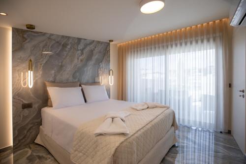 a bedroom with a large bed and a large window at Santerra Suites in Rhodes Town