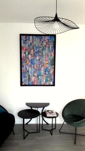 a painting on a wall with two chairs and a table at House close to the town center and the beach in Quiberon