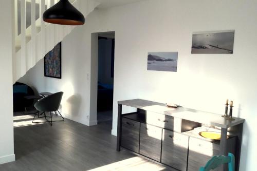 a living room with a desk and a staircase at House close to the town center and the beach in Quiberon