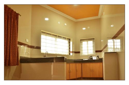 cocina grande con fregadero y 2 ventanas en Hotel GVS Residency, en Yercaud