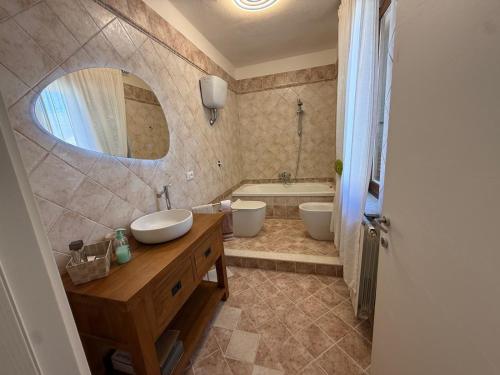 a bathroom with two sinks and a tub and a mirror at Reale Home in Casa Tonietti