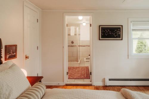 a white room with a door leading to a shower at Wren Cottage - Design Cabin with Secret Brook in Cochecton