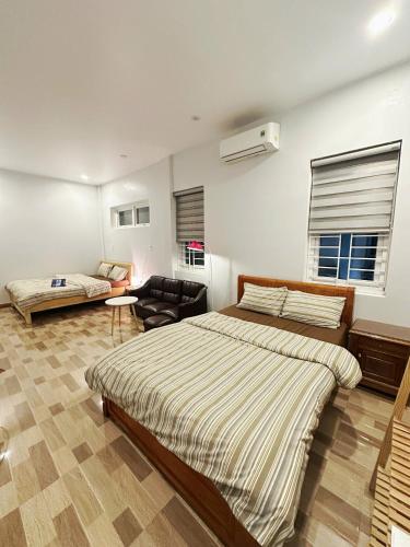 a bedroom with a large bed and a couch at Viha Homestay in Thôn Trường Giang