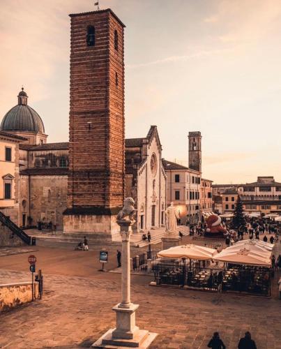 a building with a clock tower in a city at Michelangelo Escape Suite in Pietrasanta