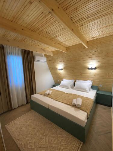 a bedroom with a large bed in a wooden room at Cozy Cottage Martvili in Martvili