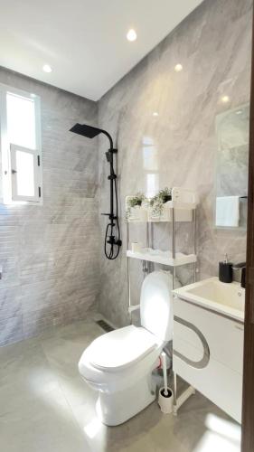 a bathroom with a white toilet and a sink at KAZA Aouchtame 2 in Laʼzîb