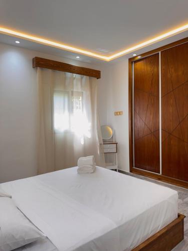a bedroom with a large bed and a wooden cabinet at KAZA Aouchtame 2 in Laʼzîb