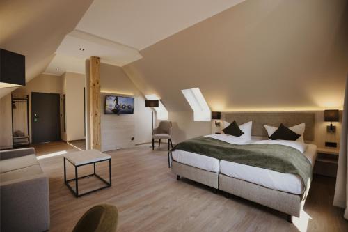 a bedroom with a bed and a living room at Seehotel Heidehof in Klein Nemerow