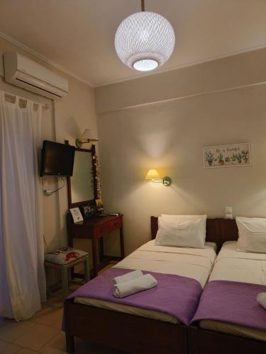 a hotel room with two beds and a television at Olive apartment in Adelianos Kampos