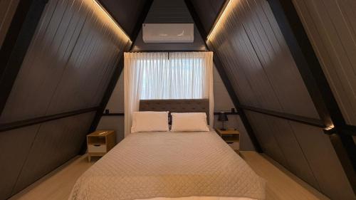 a small bedroom with a bed with a window at Cabana WSA Piratuba SC in Piratuba