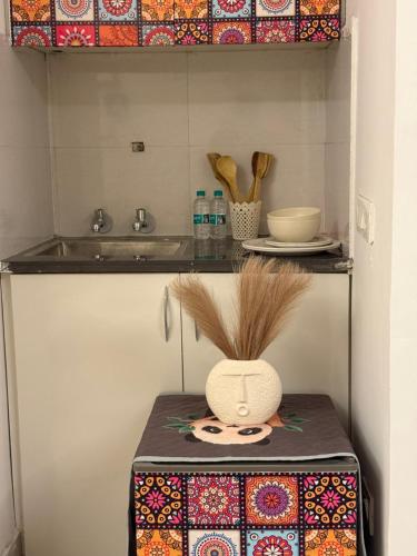 a kitchen with a sink and a table with a vase at Flippy Escapes in Zirakpur