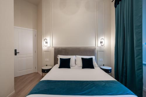 a bedroom with a large white bed with two pillows at Aethel Guesthouse in Rome