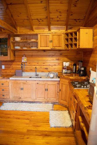 a kitchen with wooden cabinets and a sink at Rancho Canto da Lua in Urubici