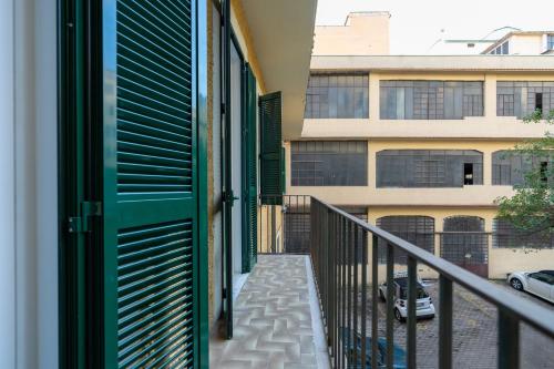 a balcony with a green door and a building at Aethel Guesthouse in Rome