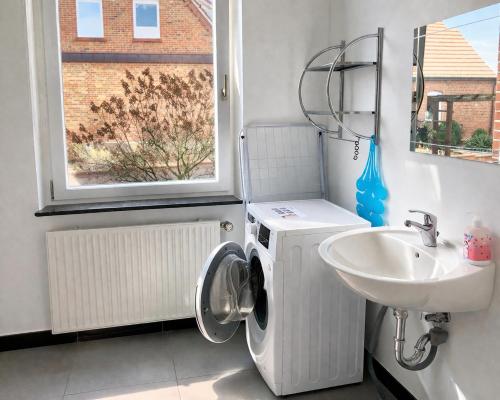 a bathroom with a washing machine and a sink at Monteurwohnungen in Andervene in Andervenne Oberdorf