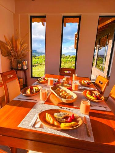 a wooden table with plates of food on it at Laguna de Cuicocha Guest House in Urcusiqui