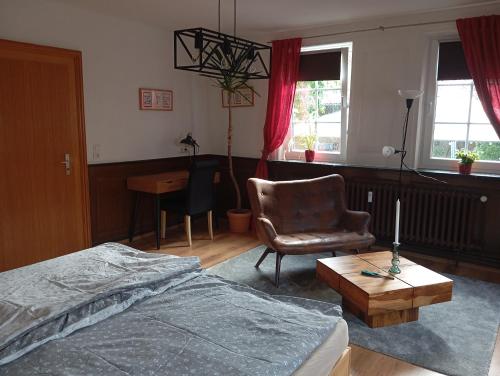 a bedroom with a bed and a chair and a table at Zwischen Acker und Herz Hartmannshof in Algermissen