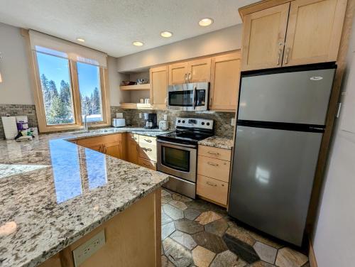 a kitchen with a stainless steel refrigerator and cabinets at Argentine 1516 by SummitCove Lodging in Colorado in Keystone