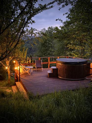 a wooden deck with a hot tub and a chair at Dom w górach Saganówka Beskidy in Międzybrodzie Bialskie