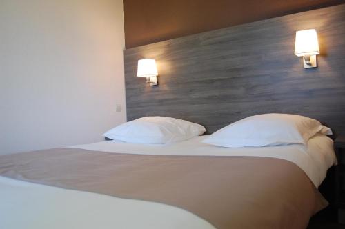 Ένα ή περισσότερα κρεβάτια σε δωμάτιο στο Logis Hotel des Portes de Meuse