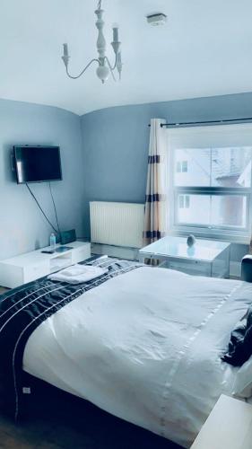 a bedroom with a large white bed and a window at Bedford Station Rest Stop in Bedford