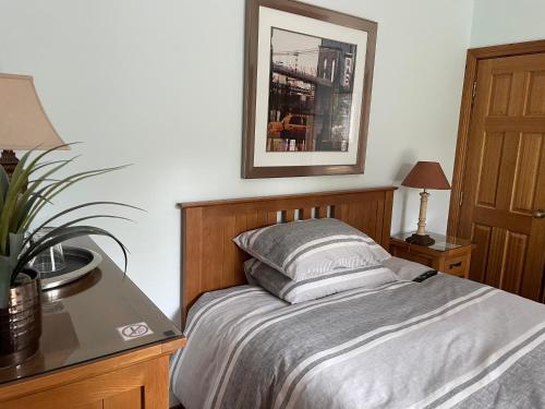 a bedroom with a bed with a table and a picture on the wall at Old Mills Garden in Elgin