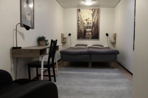 a bedroom with a bed and a desk and a table at Vandrarhemmet Eken in Eksjö