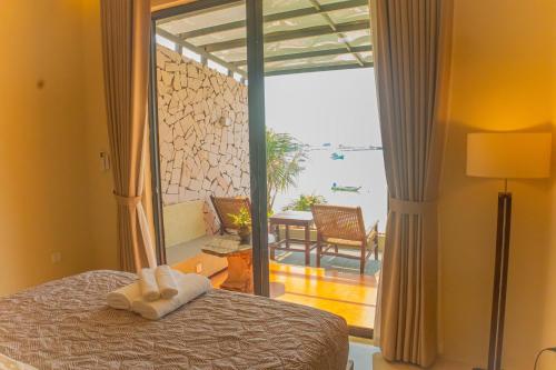 a bedroom with a bed and a view of the ocean at Chill Beach House in Phú Quốc