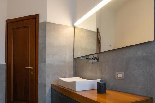 a bathroom with a white sink and a mirror at Emilia Suite Space in Modena