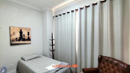 a bedroom with a bed and a window with curtains at Apartamento em Campinas a 300m do Centro in Campinas